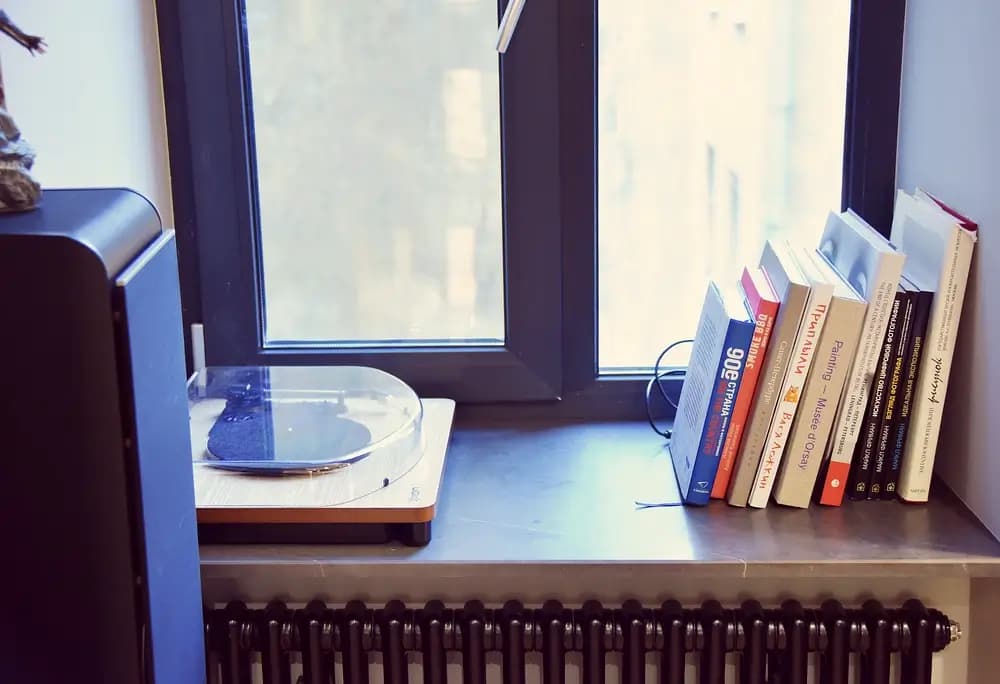 רדיאטורים שחורים במרקם מט, המתכתבים עם אדני חלון מאבן שחורה.